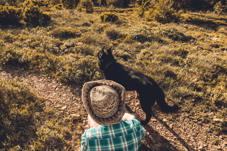 Man in a hat with his dog in the field. Guy with his dogの写真素材
