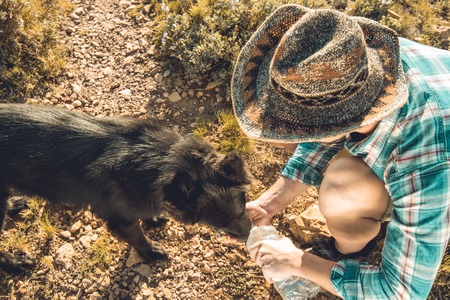 Man drinking water for his dog .Guy giving his dog waterの写真素材