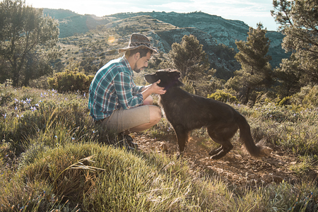 Man petting his dog and playing with it. Guy petting his dog.の写真素材