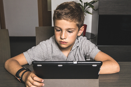 Child watching a tablet at home. Concept children with technologyの写真素材