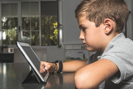 Child watching a tablet at home. Concept children with technology