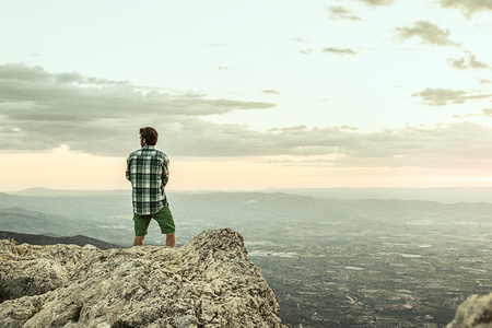 Man hiking in the mountains. And dressed in a plaid shirtの写真素材