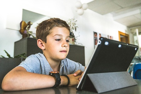 Child watching a tablet at home. Concept children with technology