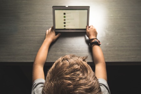 Close up behind a child looking at a tablet.Boy looking at a tabletの写真素材