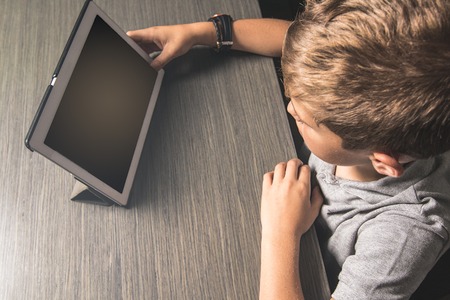 Child looking at a tablet. Middle-aged boy. Technology concept for children