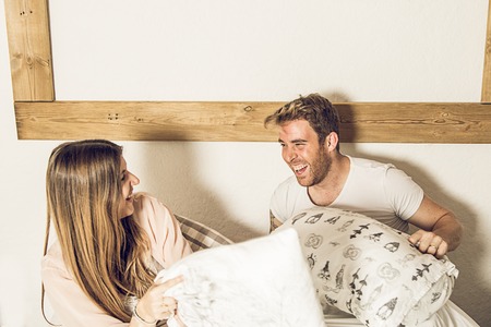 Couple of guy and girl in bed smiling and happy. Couple of girl and guy showing affection in bed. Concept of love between couplesの写真素材