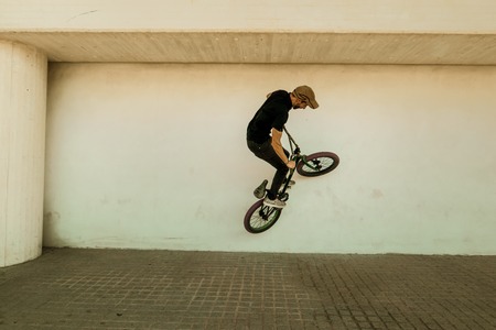 Guy riding a bmx bike on the street. Freestyle BMX in the city, extreme sports conceptの写真素材