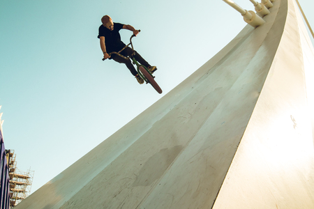 Young man doing street tricks with a bmx. Extreme urban sports conceptの写真素材