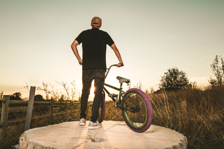 BMX rider at sunset. Guy riding a bmx bike. Urban sports conceptの写真素材
