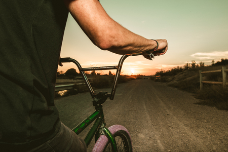 Close-up of a guy with a bicycle in a sunset. BMX riderの写真素材