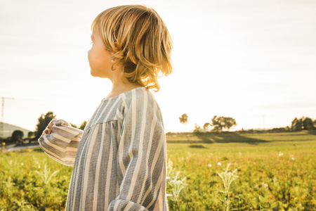 Portrait of a little blonde girl in the countryside Concept of handsome childrenの写真素材