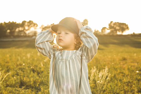 Portrait of a little blonde girl with a cap. Concept of portraits of funny childrenの写真素材