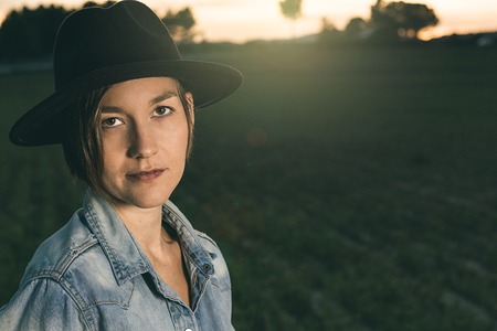 Portrait of a woman in a black hat in the country. Photography style social networksの写真素材