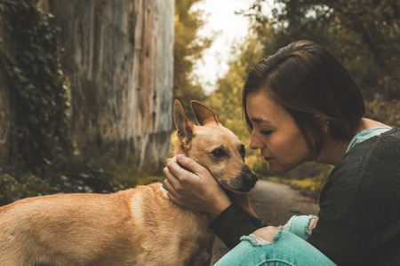 Happy girl stroking and kissing her dog.Concept love between girl and dogの写真素材