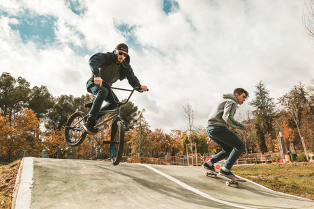 Young skateboarders and bmx bikes. Young people practicing sports in the cityの写真素材