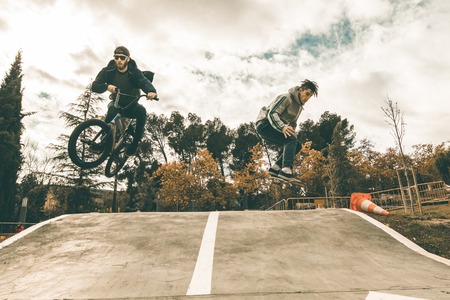 Young skateboarders and bmx bikes. Young people practicing sports in the city