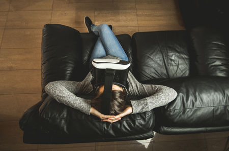 A young woman at home with VR glasses. Virtual Reality Goggles Conceptの写真素材