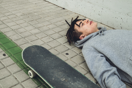 Portrait of a guy with a skateboard. Skateboarder in the street of a cityの写真素材