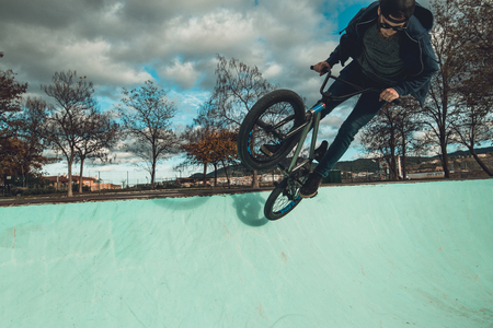 Boy riding and jumping bmx bike in a park.Extreme urban sportsの写真素材