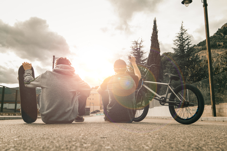 Young people with bikes and skateboards in the city. Urban sports concept for teenagersの写真素材