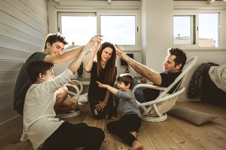 A happy family at home with fun and positive expression. Concept of love and affection of a united familyの写真素材