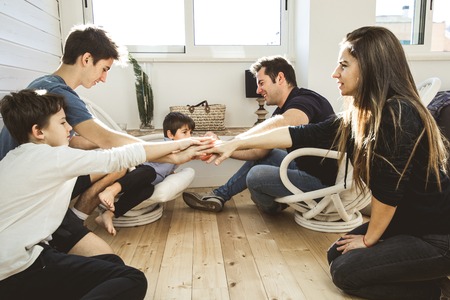 A happy family at home with fun and positive expression. Concept of love and affection of a united familyの写真素材