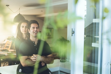A woman hugging a man at home. Romantic concept of love and affection between couples.Young couple embracingの写真素材