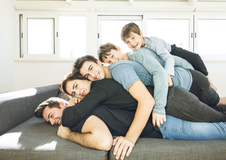 Portrait of a happy, smiling family on the couch at home. Concept of a united and fun family lifestyle.の写真素材