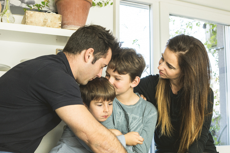 Portrait of a happy family kissing and hugging at home. Concept family lifestyle showing affectionの写真素材