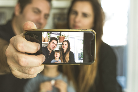 A family making a selfi with their son at home. Harmony and happiness in family