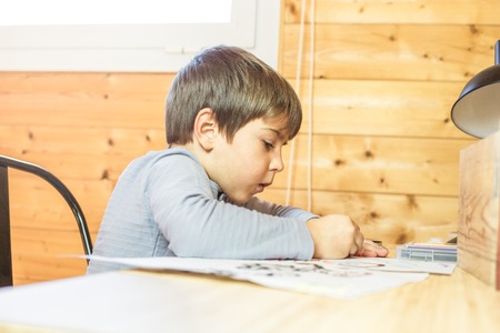 Portrait of a child drawing in his room. Close-up of a kid painting a picture