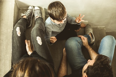 Family with happy son and smiling sitting on the stairs at home. Portrait of a couple with a happy child playingの写真素材