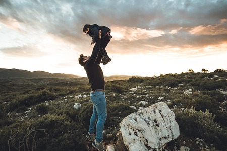 Father throwing his son into the air. Concept of happiness and love between dad and childの写真素材