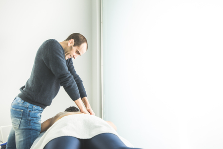 Physiotherapist working doing a massage on a patient back. Concept of physiotherapy and rehabilitationの写真素材