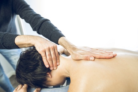 Close-up of a physiotherapist massaging the neck of a beautiful young woman. Concept physiotherapy and healthの写真素材