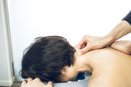 Close-up of a physiotherapist massaging the neck of a beautiful young woman. Concept physiotherapy and healthの写真素材