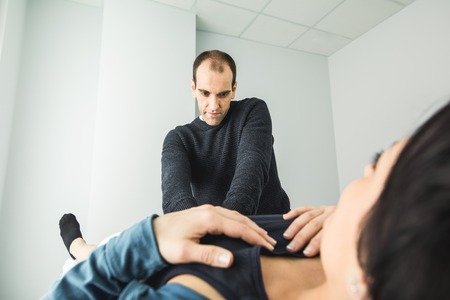 Physiotherapist treating a young woman knee. Concept of physiotherapy, rehabilitation and healing