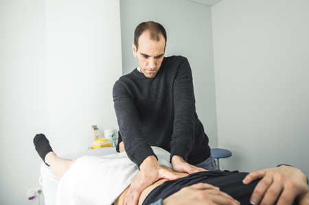 Physiotherapist massaging the belly of a young woman.Physiotherapy and recoveryの写真素材