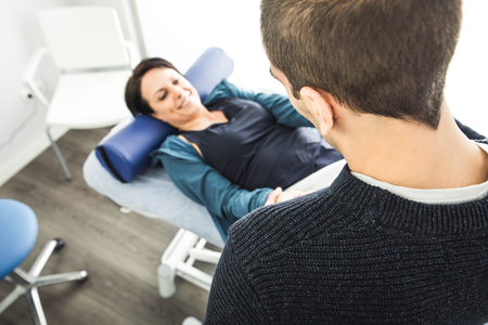Physiotherapy and recovery. Physiotherapist massaging the wrist of a young woman.の写真素材