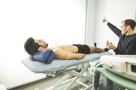 Physiotherapist examining a patient with an ultrasound scan.Advanced elbow physiotherapyの写真素材