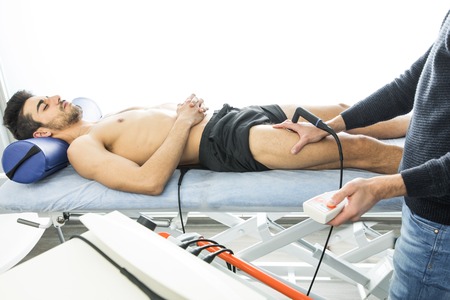 Physiotherapist treating a patient with an ultrasound machine. Advanced physiotherapy techniques