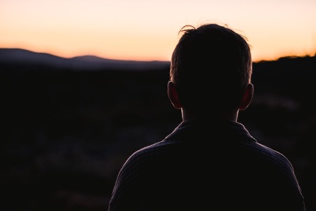 Portrait of a silhouette of a little boy in a sunset in the countryside. Child in natureの写真素材