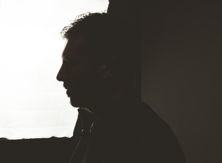 Portrait of a silhouette of a guy in a studio. Dramatic photoの写真素材