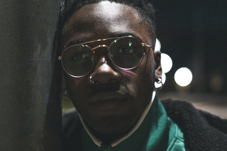 Close up Handsome African-American guy with glasses on the street. Portrait black man serious