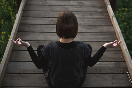Girl meditating and practicing yoga in nature. Concept of exercise and relaxation