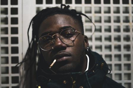 Portrait of young black man and handsome confident and trendy in the street
