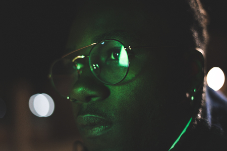 Retro neon portrait of an African American. Close-up black man with modern glassesの写真素材