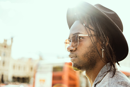Handsome african american guy with style and modern sunglasses and hatの写真素材