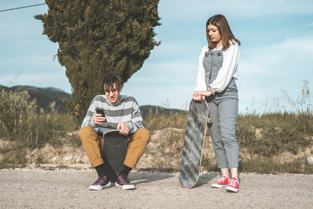 Millennial young couple happy having fun with skateboarding. Concept of young people practicing urban sportsの写真素材