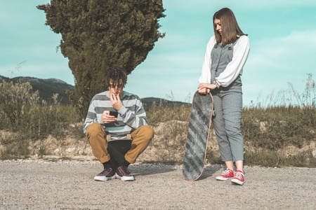 Millennial young couple happy having fun with skateboarding. Concept of young people practicing urban sportsの写真素材